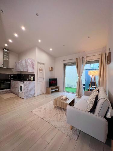 un salon avec un canapé et une grande fenêtre dans l'établissement Maison Cosy Sannois, à Sannois