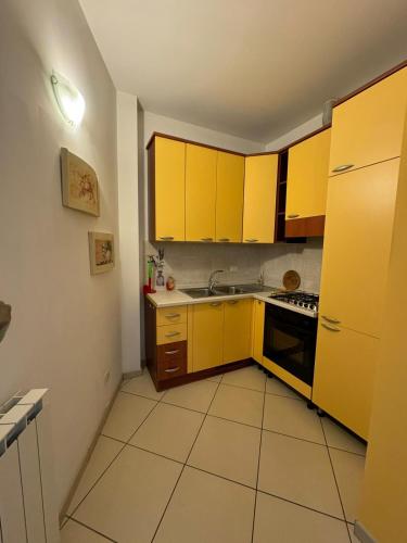 a small kitchen with yellow cabinets and a stove at La casa di Glenda ospedale in Terni