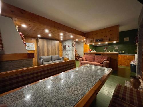 a kitchen and living room with a couch and a table at Villa La Roccia Scopello Valsesia in Scopello