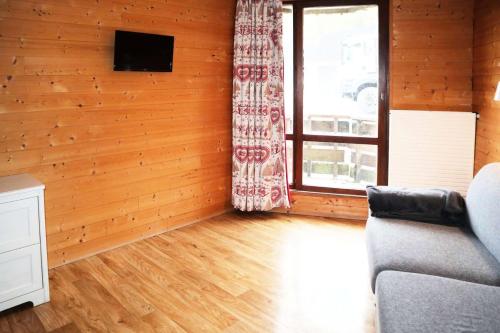 un salon avec un canapé et une fenêtre dans l'établissement Residence Le 1650 - Studio pour 3 personnes cœur de station des Orres 1650 MAE-5891, aux Orres