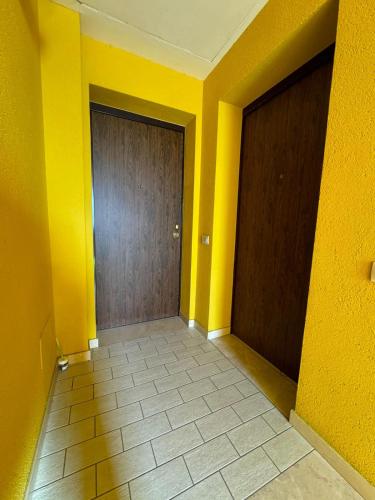 an empty hallway with yellow walls and a door at La casa di Glenda ospedale in Terni