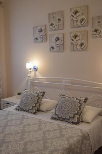 a bedroom with a bed with two pillows and pictures on the wall at Athina studios in Ýpsos
