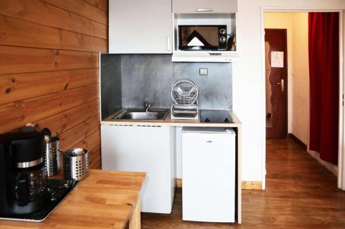 une petite cuisine avec un évier et un micro-ondes dans l'établissement Residence Le 1650 - Studio pour 2 personnes cœur de station des Orres 1650 MAE-5921, aux Orres