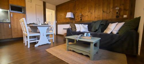 ein Wohnzimmer mit einem Sofa und einem Tisch in der Unterkunft Appartement VERCORS 4 personnes in Autrans