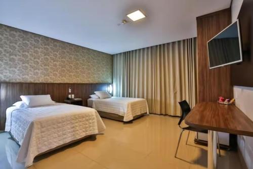 a hotel room with two beds and a desk at Ucayali Hotel in Sinop