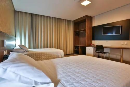 a hotel room with two beds and a desk at Ucayali Hotel in Sinop