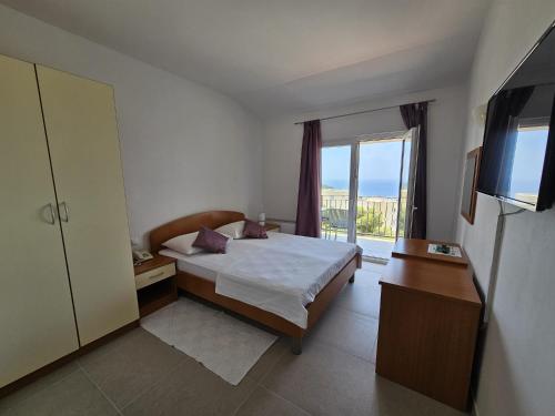1 dormitorio con cama y ventana grande en Pansion Komfor Moča, en Makarska