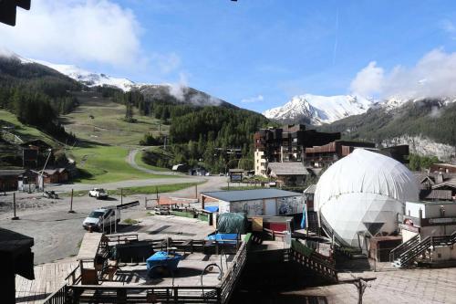 un grand bâtiment blanc en forme de dôme avec des montagnes en arrière-plan dans l'établissement Residence Le 1650 - Studio pour 2 personnes cœur de station des Orres 1650 MAE-5941, aux Orres