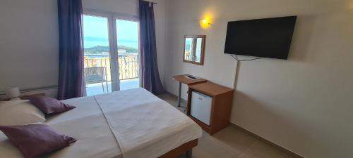 1 dormitorio con 1 cama y TV de pantalla plana en Pansion Komfor Moča, en Makarska