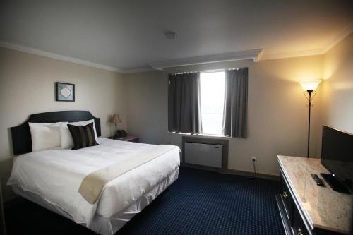 a hotel room with a bed and a window at Montecassino Hotel & Suites in Toronto