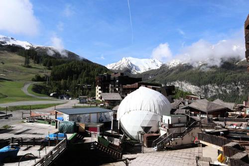 un grand bâtiment blanc en forme de dôme devant une montagne dans l'établissement Residence Le 1650 - Studio pour 2 personnes cœur de station MAE-5951, aux Orres
