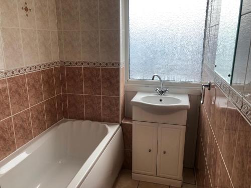 a bathroom with a bath tub and a sink at Villa 118 Dawlish Warren in Dawlish Warren