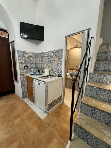 a kitchen with a sink and a staircase in a house at CAMINNECI PALACE & ROOMS in Palermo