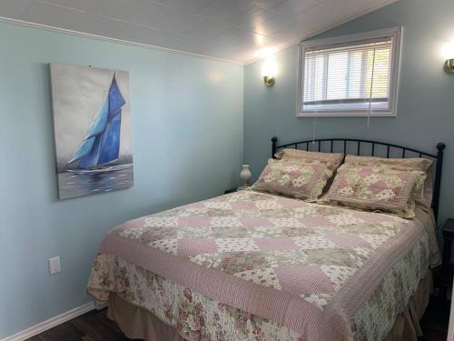 a bedroom with a bed with a blue wall at Hillside Cottage in Twillingate