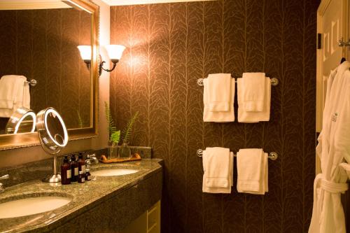 a bathroom with two sinks and a mirror and towels at The Lodge at Woodloch in Hawley