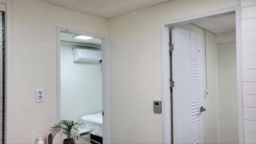 a bathroom with a door and a mirror and a room at Seoul Tower Ville in Seoul