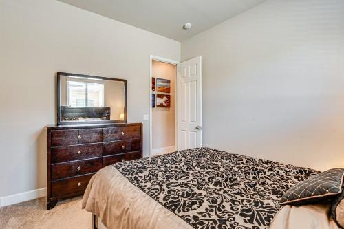 a bedroom with a bed and a dresser and a mirror at Beautiful Bakersfield Home about 8 Mi to Downtown! in Bakersfield