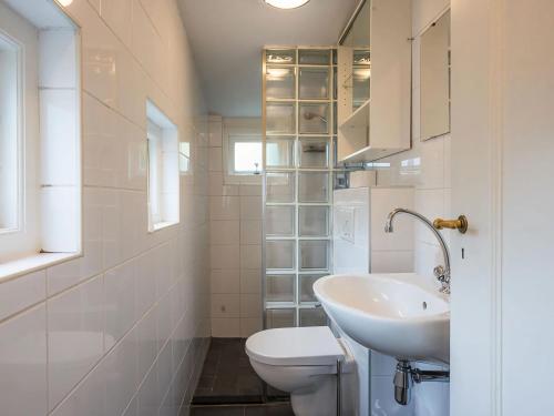 een witte badkamer met een wastafel en een toilet bij Cosy holiday home in Veere near lake in Veere