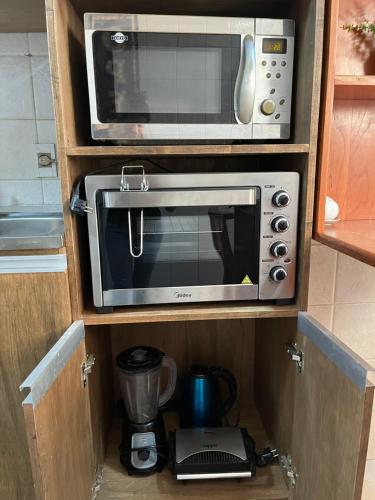 a microwave and a toaster oven in a kitchen at Apartamento Paraguayo - Proximo a Estadios Pablo Rojas La nueva Olla y Defensores del chaco - Centro historico in Asuncion