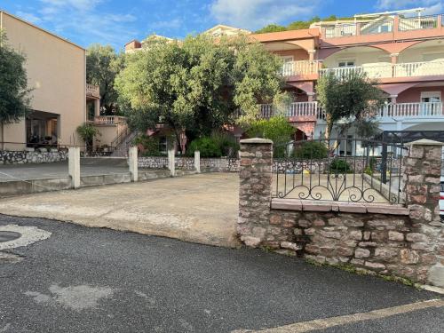 a stone fence on the side of a street at Private Patio Przno Steps to Beach 2 Bedroom 2 Parkings BBQ Villa Olive in Sveti Stefan
