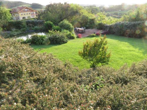 a large yard with grass and trees and a house at La casa de las palas Tok-pok in Mogro