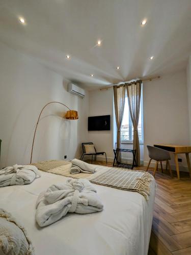 une chambre avec deux lits avec des serviettes dessus dans l'établissement My'Deting - Jacuzzi, à Roanne