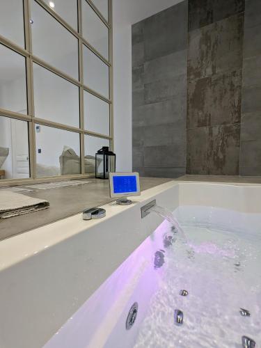 d'une baignoire avec un ordinateur portable. dans l'établissement My'Deting - Jacuzzi, à Roanne