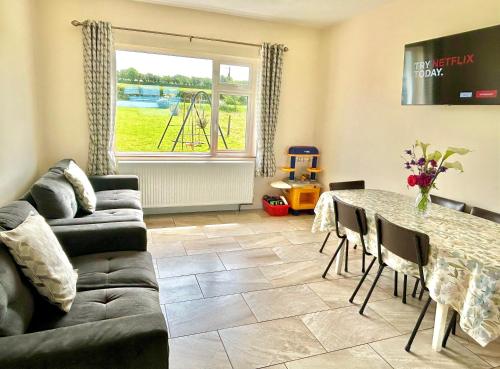 a living room with a couch and a table at Breenville Farm House in Tralee