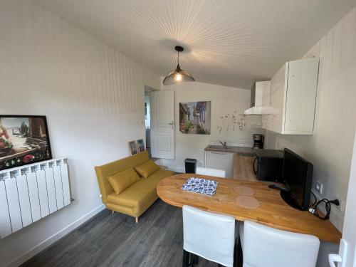 un salon avec une table et un canapé dans l'établissement Au parfum des fleurs, à Saint-Médard-en-Jalles