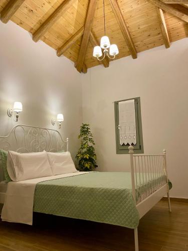 a bedroom with a bed and a wooden ceiling at Oneiropetra Luxury House in Argalasti