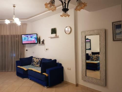 a living room with a blue couch and a mirror at Beralmar in Asilah