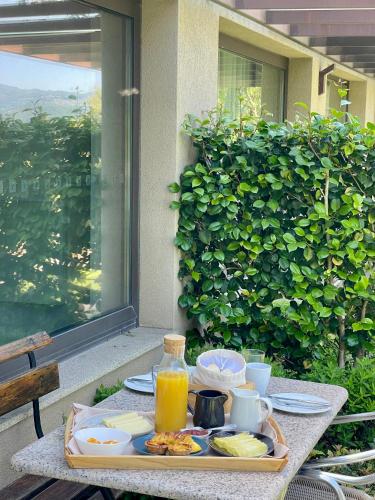 una bandeja de comida en una mesa con zumo de naranja en Bosque da Harmonia, en Arco de Baúlhe