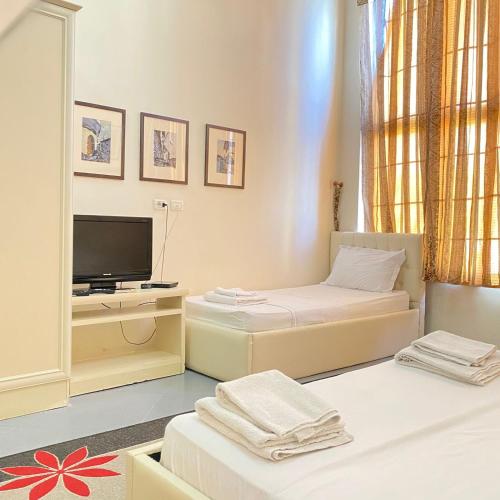 a small room with two beds and a television at Hotel Pasarela in Berat