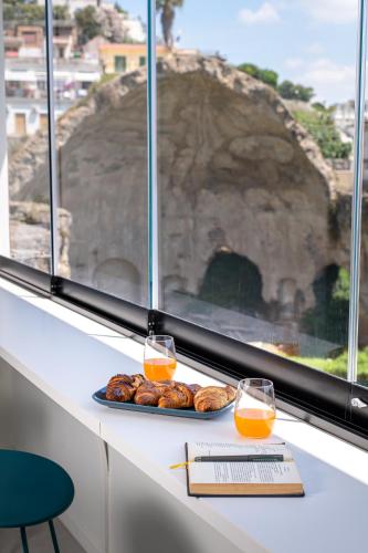 un piatto di cibo su un bancone con due bicchieri di succo d'arancia di Domus Diana a Bacoli
