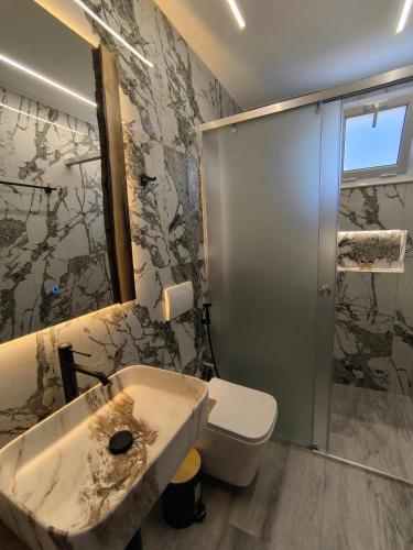 a bathroom with a sink and a toilet at Villa Bodini Himare in Himare