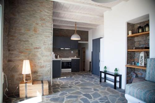 a living room with a stone wall and a couch at Villa with infinity pool and exceptional sea view in Kithnos