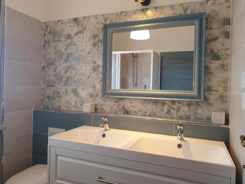 ein Badezimmer mit einem Waschbecken, einem Spiegel und einem WC in der Unterkunft Temporary Home Silvi 3 in Silvi Marina