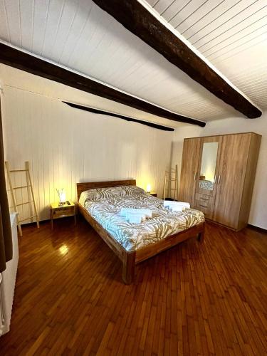 a bedroom with a bed in a room with wooden floors at Casa9cento in Omegna
