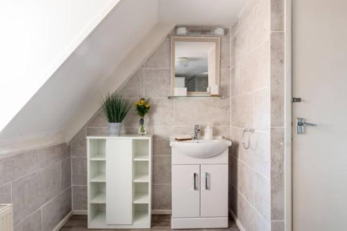 a white bathroom with a sink and a mirror at The Hideaway, lovely cosy place in Blandford Forum, Dorset in Blandford Forum