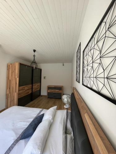 une chambre avec un lit et un mur blanc dans l'établissement Gîte - le temps d'une pause, à Sauveterre