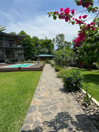 a garden path with flowers and a swimming pool at Southern Drake Lodge in Drake
