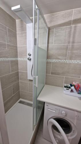 une salle de bain avec douche et machine à laver dans l'établissement Studio 2 pers, rez-de-chaussée, grande terrasse plein sud, à Font-Romeu-Odeillo-Via