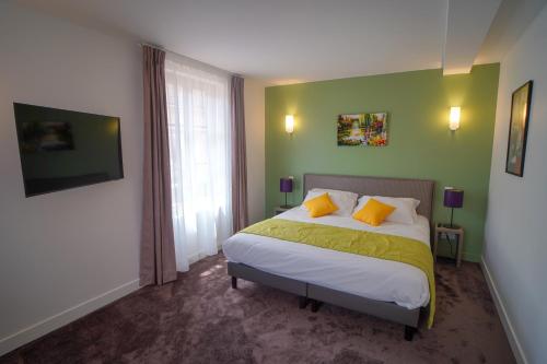 a bedroom with a bed with yellow and green walls at Hôtel de la Croix Blanche in Villiers-Saint-Benoît
