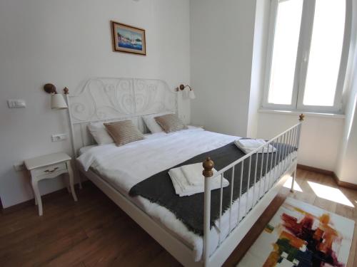 a bedroom with a white bed with a crib at Papavero rooms in Pula