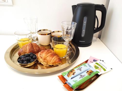 a breakfast tray with croissants and orange juice and coffee at Papavero rooms in Pula