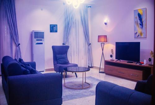 a living room with a couch and a tv at 3 bedroom Greys Apartment Lifecamp Abuja in Tungan Daudu