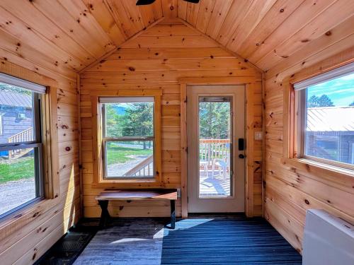 a log cabin with a bench in a room with windows at BMV7 Tiny Home village near Bretton Woods in Twin Mountain