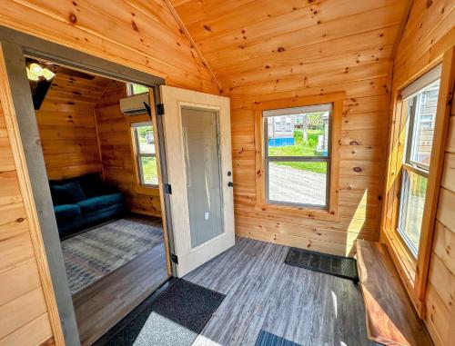 a wooden cabin with a door and a couch at BMV7 Tiny Home village near Bretton Woods in Twin Mountain