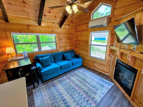 a living room with a blue couch and a tv at BMV7 Tiny Home village near Bretton Woods in Twin Mountain