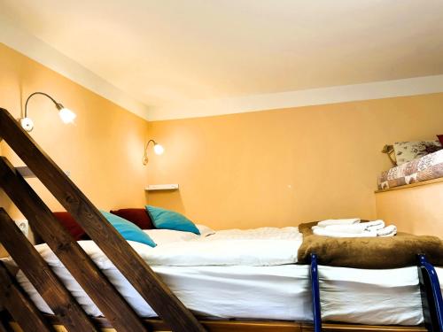 a bedroom with two beds and a stair case at Penzion Kersko in Hradišťko